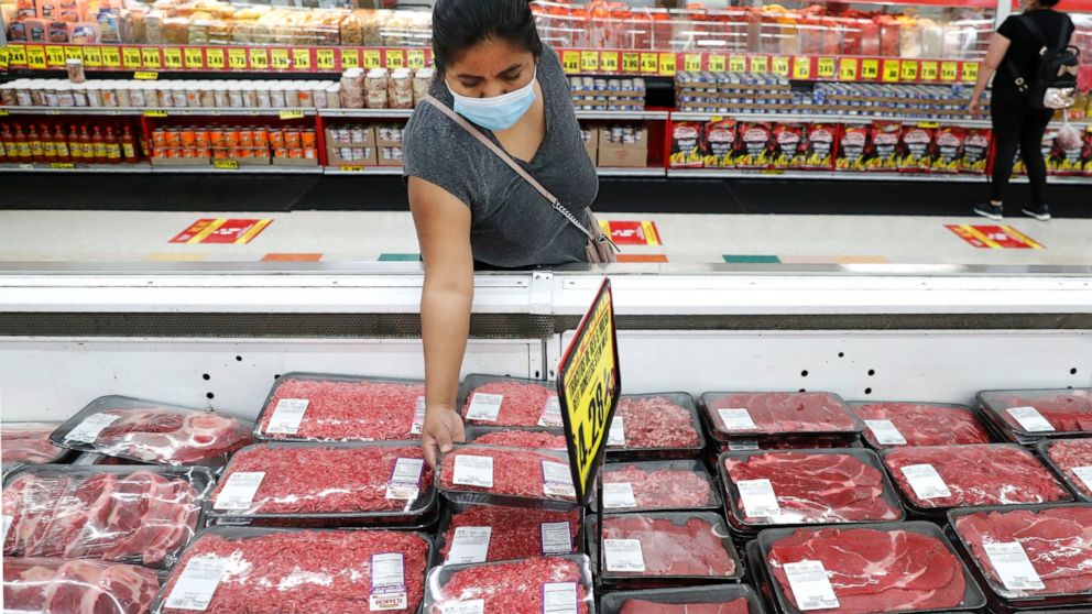 FILE - In this April 29, 2020 file photo, a shopper wears a mask as she looks over meat products at a grocery store in Dallas. Wholesale prices rose a higher-than-expected 0.6% in April, driven by a sharp rise in food costs. The increase, reported Th