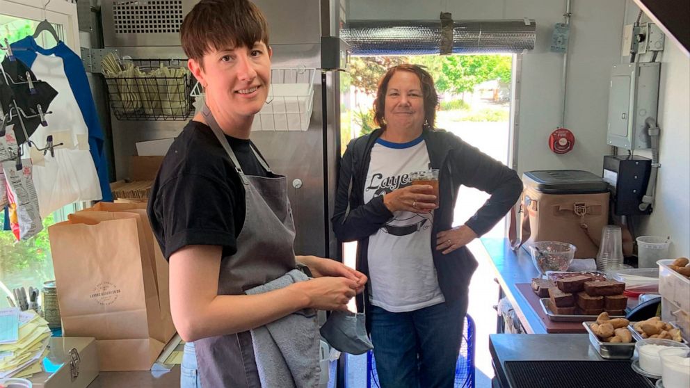 In this image provide by Ashley Hardin, Ashley Hardin, 38, of Seattle, and her mother, Lajay Gove, pose inside Layers Sandwich Co., a food truck Hardin runs with her husband, Avery Hardin, on May 29, 2021, in Seattle. Ashley Hardin will have about $1
