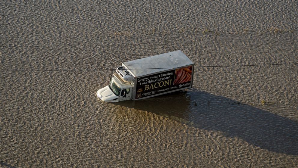 A truck is stranded along a flooded road in Abbotsford, British Columbia, Tuesday, Nov. 16, 2021. (Jonathan Hayward/The Canadian Press via AP)