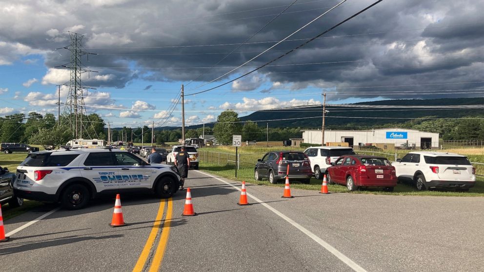 Law enforcement vehicles block the road at the scene of a shooting at a Maryland business near Smithsburg, Md., on Thursday June, 9 2022. A man opened fire at a manufacturing business in rural western Maryland on Thursday, killing multiple people bef