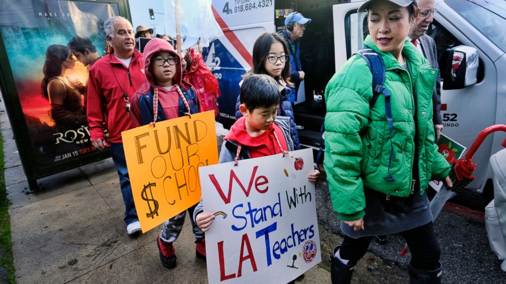 Parents, teachers and students carry signs and picket in front of Hamilton High School, Wednesday, Jan. 16, 2019, in Los Angeles during a citywide teacher strike. (AP Photo/Richard Vogel)