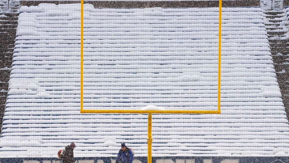 Grounds crew work to clear snow off the field at Highmark Stadium before an NFL football game between the Buffalo Bills and the Miami Dolphins in Orchard Park, N.Y., Saturday, Dec. 17, 2022. (AP Photo/Gene J. Puskar)