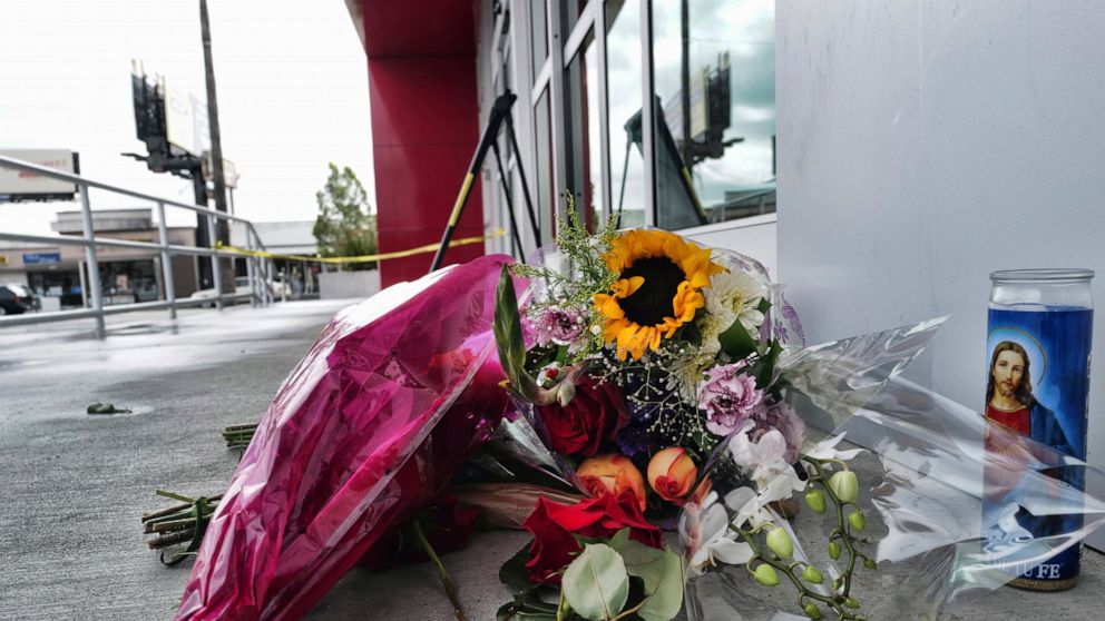 A votive candle and flowers are left for a teen who was fatally shot at a department store in the North Hollywood section of Los Angeles on Saturday, Dec. 25, 2021. The coroner's office has identified the 14-year-old girl who was fatally shot by Los 