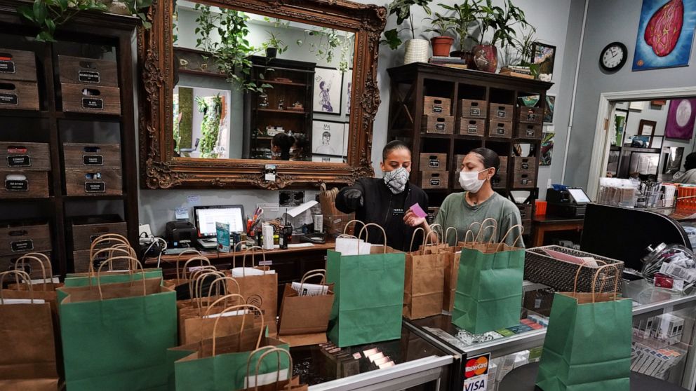 FILE - In this April 16, 2020, file photo, budtenders wearing protective masks prepare orders for customers to pick up at the Higher Path cannabis dispensary in the Sherman Oaks section of Los Angeles. A Los Angeles City Council committee approved on