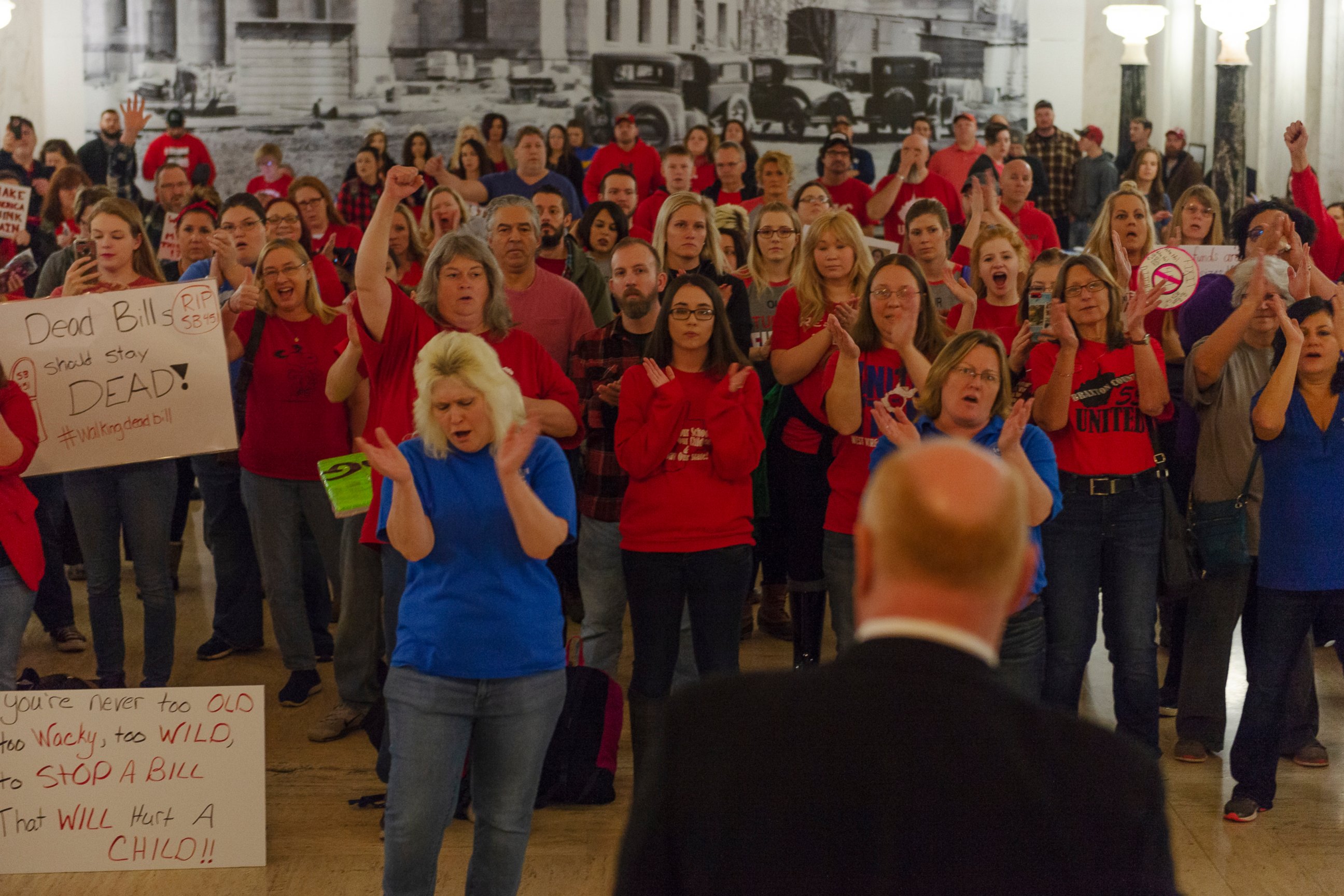 Teachers and school personnel clap as West Virginia Education Association President Dale Lee speaks in front of the House of Delegates chamber at the West Virginia State Capitol in Charleston, W.Va. on the second day of a statewide strike by teachers