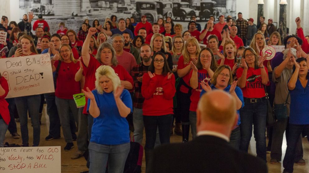 Teachers and school personnel clap as West Virginia Education Association President Dale Lee speaks in front of the House of Delegates chamber at the West Virginia State Capitol in Charleston, W.Va. on the second day of a statewide strike by teachers
