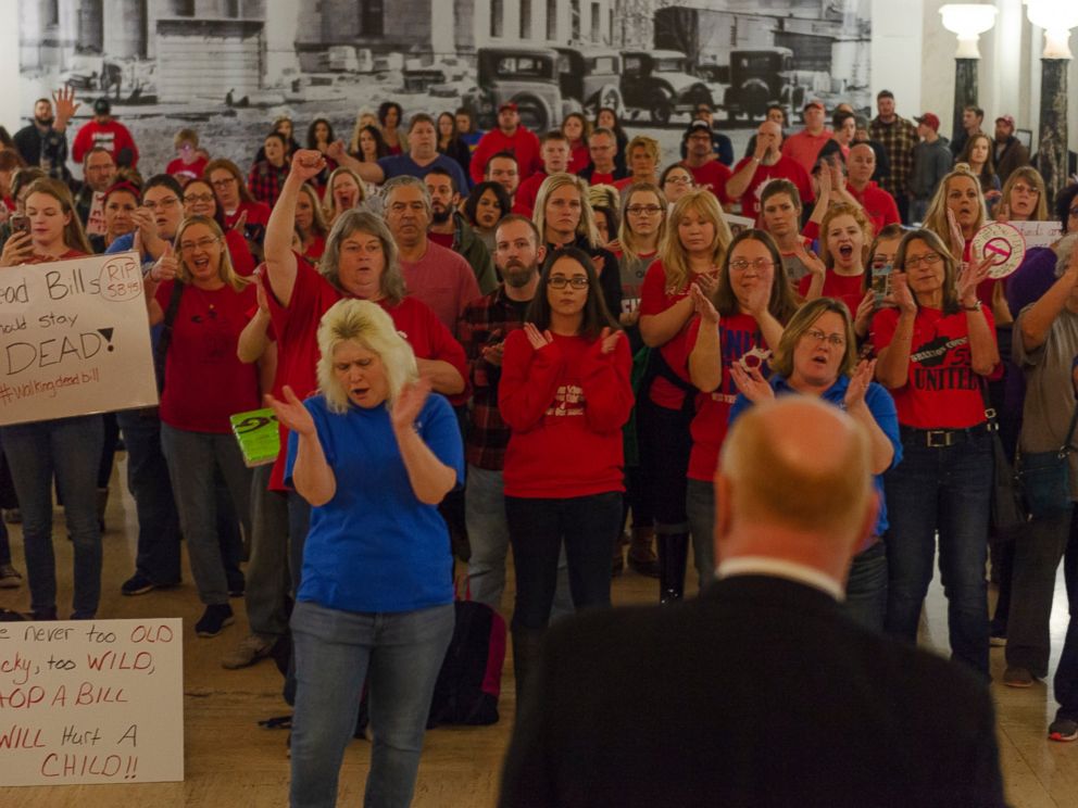 Teachers and school personnel clap as West Virginia Education Association President Dale Lee speaks in front of the House of Delegates chamber at the West Virginia State Capitol in Charleston, W.Va. on the second day of a statewide strike by teachers