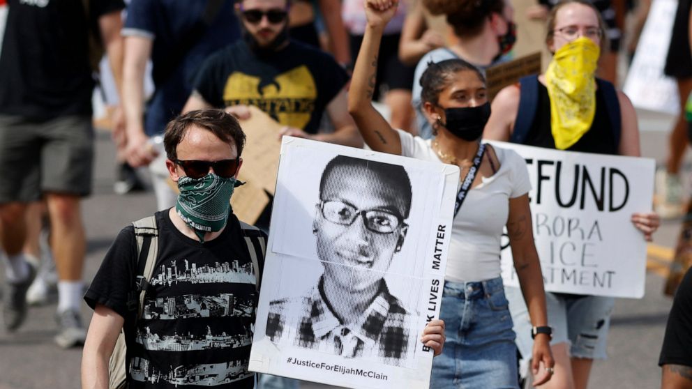 FILE - A demonstrator carries an image of Elijah McClain during a rally and march in Aurora, Colo., June 27, 2020. A Colorado judge on Friday, Sept. 16, 2022 responded to a request by a coalition of news organizations to release an amended autopsy re