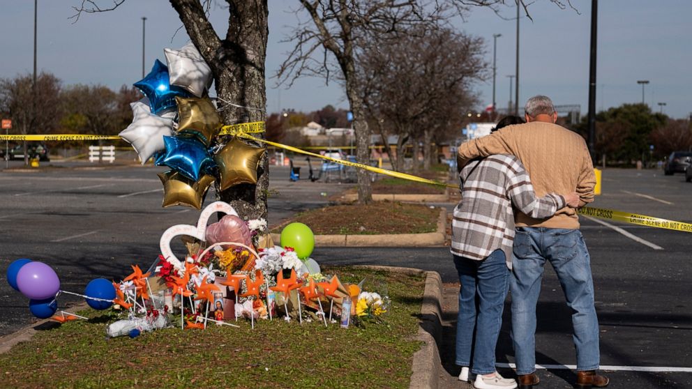 Debbie, left, and Chet Barnett place flowers at a memorial outside of the Chesapeake, Va., Walmart on Thursday, Nov. 24, 2022. Andre Bing, a Walmart manager, opened fire on fellow employees in the break room of the Virginia store, killing six people 