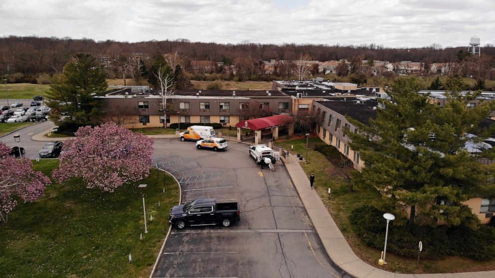 Ambulance crews are parked outside Andover Subacute and Rehabilitation Center in Andover, N.J., on Thursday April 16, 2020. Police responding to an anonymous tip found more than a dozen bodies Sunday and Monday at the nursing home in northwestern New