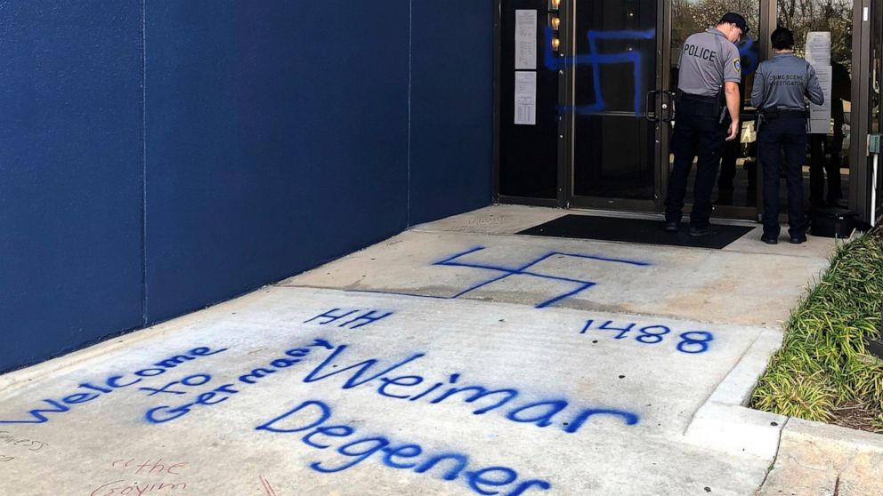 Law enforcement officers investigate racist and anti-Semitic graffiti in front of a building that houses the Oklahoma Democratic Party headquarters Thursday, March 28, 2019, in Oklahoma City. Former Democratic Gov. David Walters said Thursday that va