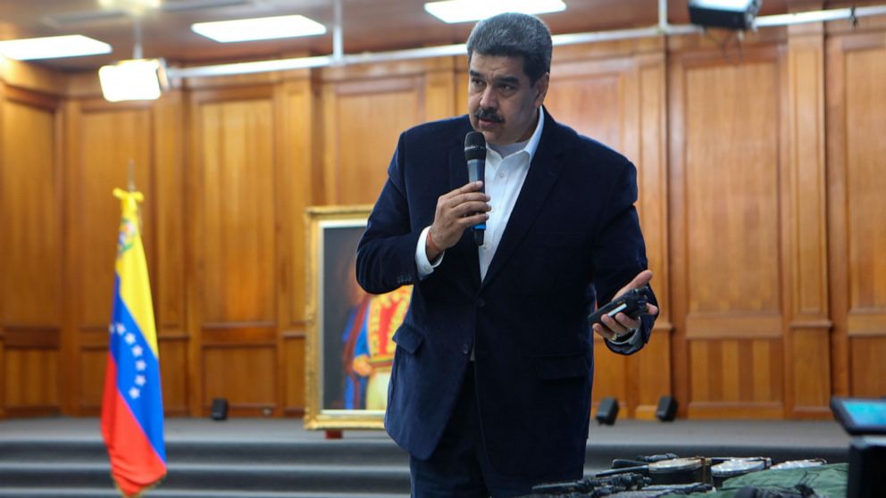 FILE- This photo released by the Venezuelan Miraflores presidential press office shows President Nicolas Maduro speaking over military equipment that he says was seized during an incursion into Venezuela, during his televised address from Miraflores 