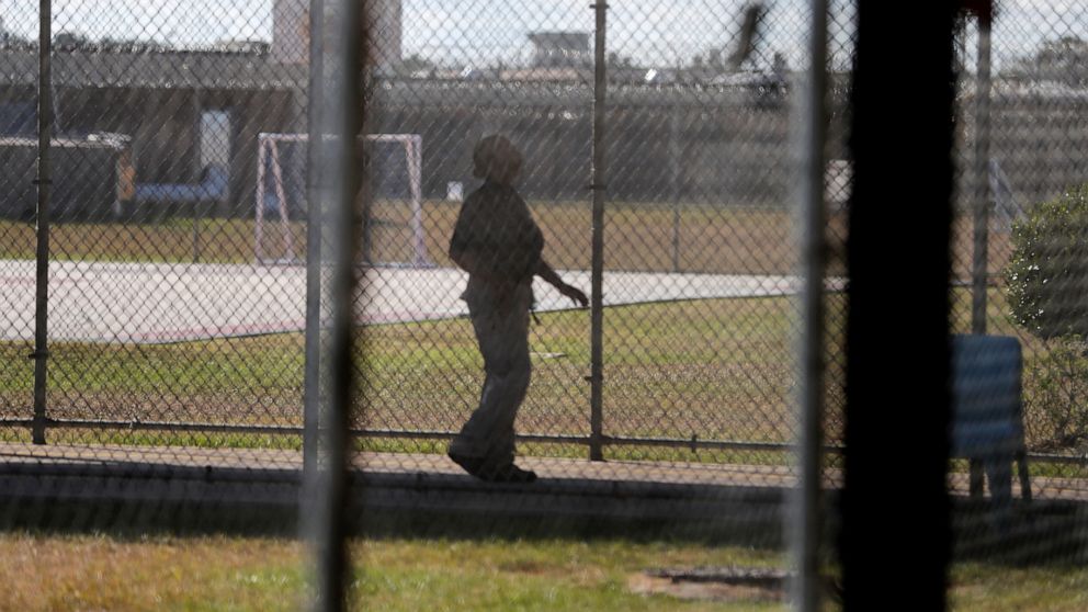 FILE - In a Thursday, Sept. 26, 2019 file photo, a guard walks on a path between yards during a media tour inside the Winn Correctional Center in Winnfield, La. U.S. Immigration and Customs Enforcement said officers inside the Winn Correctional Cente