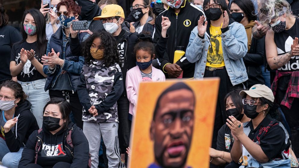 Demonstrators gather for a solidarity rally lead by community organizers in the Black and Asian communities in memory of George Floyd and Daunte Wright outside Cup Foods, Sunday, April 18, 2021, in Minneapolis. (AP Photo/John Minchillo)