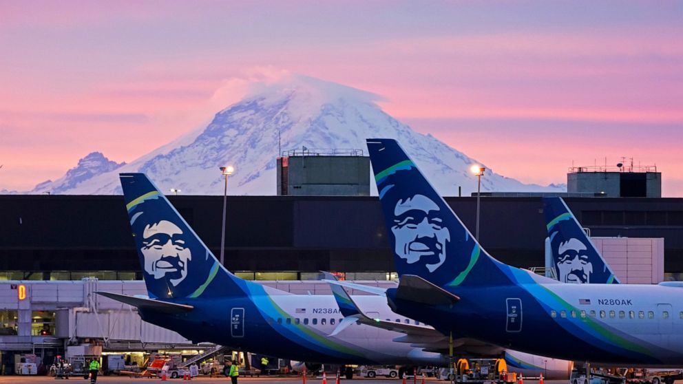 FILE - Alaska Airlines planes are parked at gates with Mount Rainier in the background at sunrise, on March 1, 2021, at Seattle-Tacoma International Airport in Seattle. A union has reached a deal Wednesday, June 22, 2022, with Seattle-based Alaska Ai