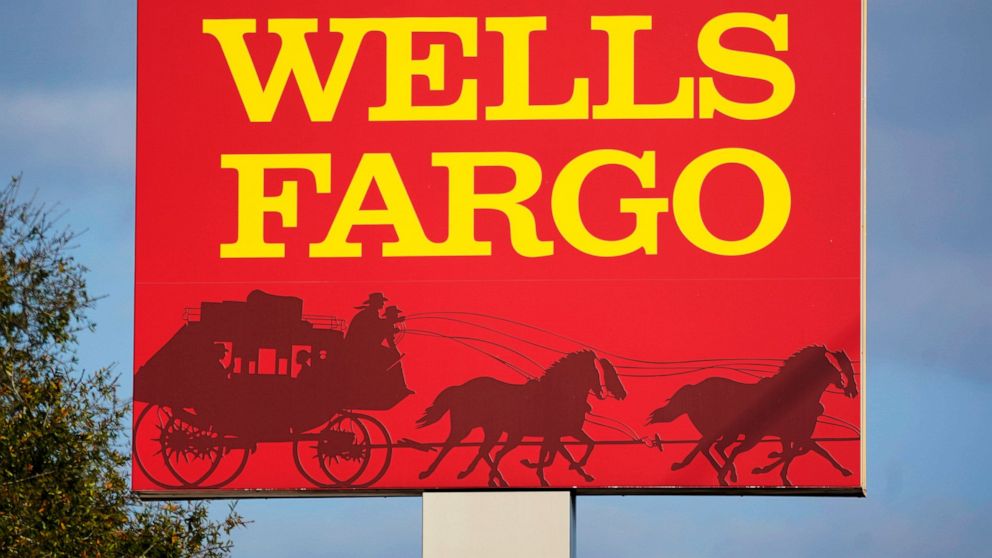 FILE - A Wells Fargo sign stands in front of a branch of the bank in Bradenton, Fla., Tuesday, Feb. 22, 2022. Consumer banking giant Wells Fargo is being ordered to pay $3.7 billion in fines and refunds to customers by U.S. government regulators, the