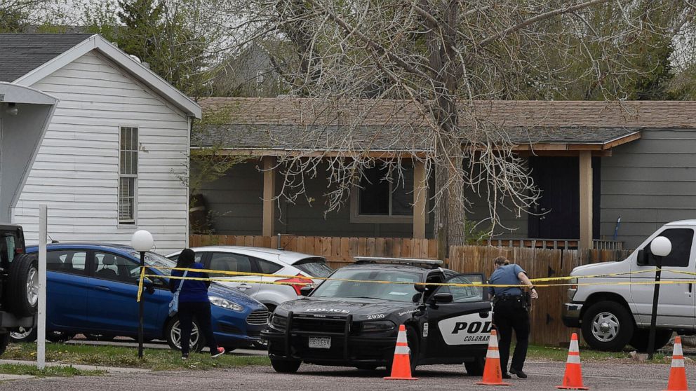 A Colorado Springs police officer goes to help a person who was in a different mobile home to be able to get to her car from behind the crime tape in Colorado Springs, Colo., Sunday, May 9, 2021. A gunman opened fire at a birthday party in Colorado, 