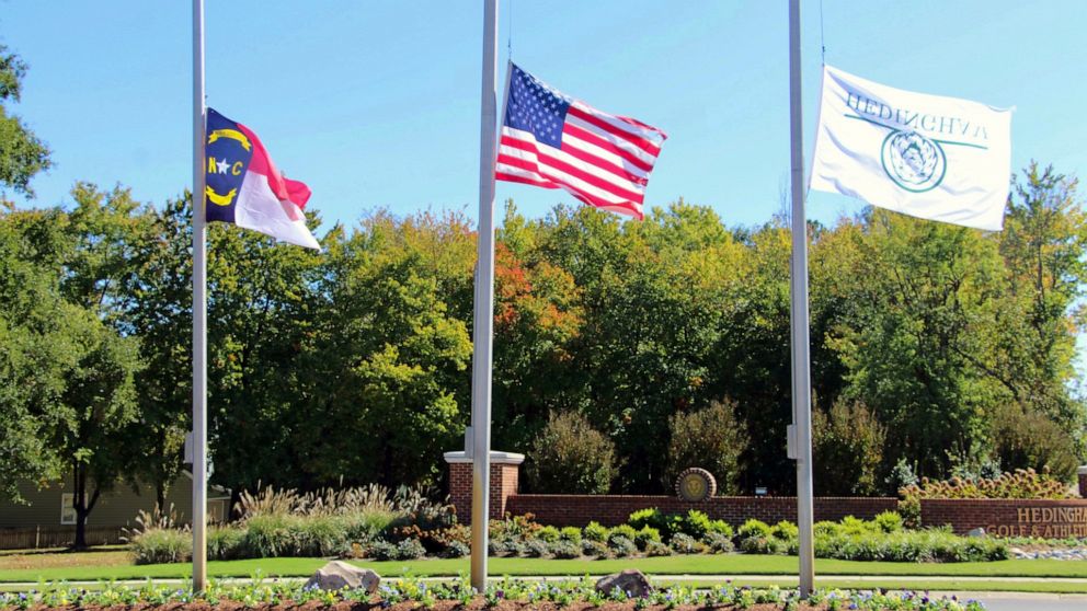 The North Carolina flag, American flag and Hedingham flag all fly at half-staff at the entrance to the Hedingham Golf Club in Raleigh, N.C., on Friday, Oct. 14, 2022, after a shooting in the community left five dead Thursday night, including one off-