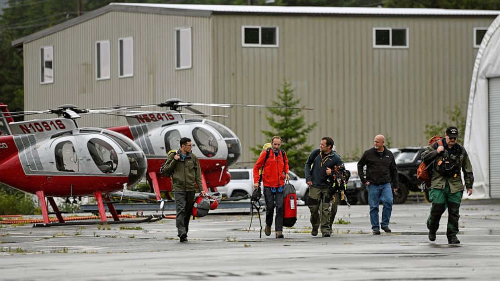 Ketchikan Volunteer Rescue Squad personnel land and disembark from a Hughes 369D helicopter on Thursday, Aug. 5, 2021, at Temsco Helicopters Inc in Ketchikan, Alaska. The KVRS, U.S. Coast Guard, Alaska State Troopers and U.S. Forest Service responded
