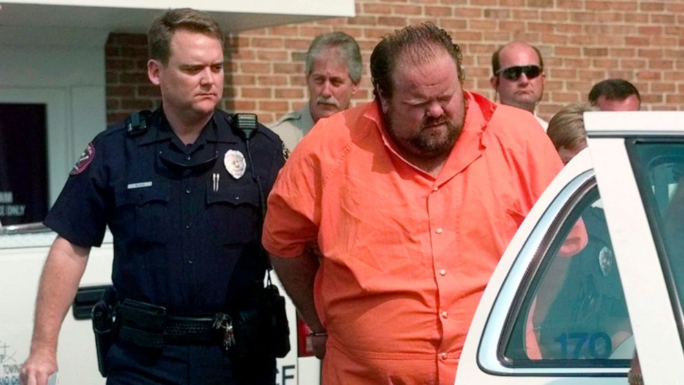 FILE - Officials escort murder suspect Alan Eugene Miller away from the Pelham City Jail in Alabama, Aug. 5, 1999. Miller said prison staff poked him with needles for over an hour as they tried to find a vein during an aborted lethal injection in Sep