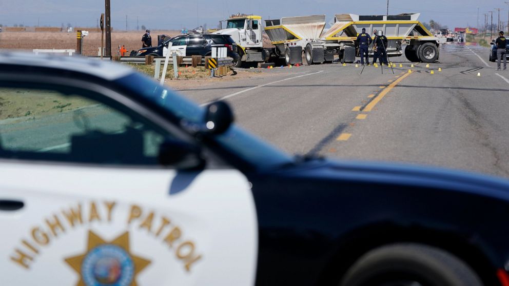Law enforcement officers work at the scene of a deadly crash in Holtville, Calif., on Tuesday, March 2, 2021. Authorities say a semi-truck crashed into an SUV carrying 25 people on a Southern California highway, killing at least 13 people. (AP Photo/