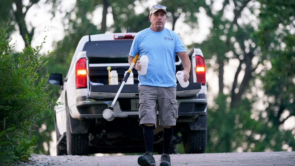 Des Moines Water Works employee Bill Blubaugh makes his way to collect a water sample from the Raccoon River, Thursday, June 3, 2021, in Des Moines, Iowa. Each day the utility analyzes samples from the Raccoon River and others from the nearby Des Moi