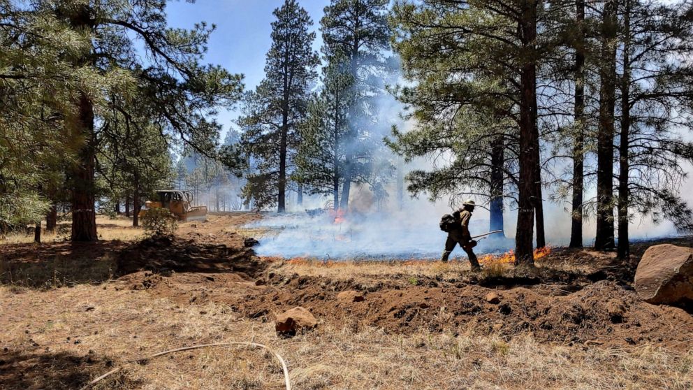 This photo provided by the Rincon Valley Fire District shows crews working a wildfire on the outskirts of Flagstaff, Ariz., on Tuesday, June 14, 2022. Rain in the forecast later this week could help firefighters battling the blaze. (Rincon Valley Fir