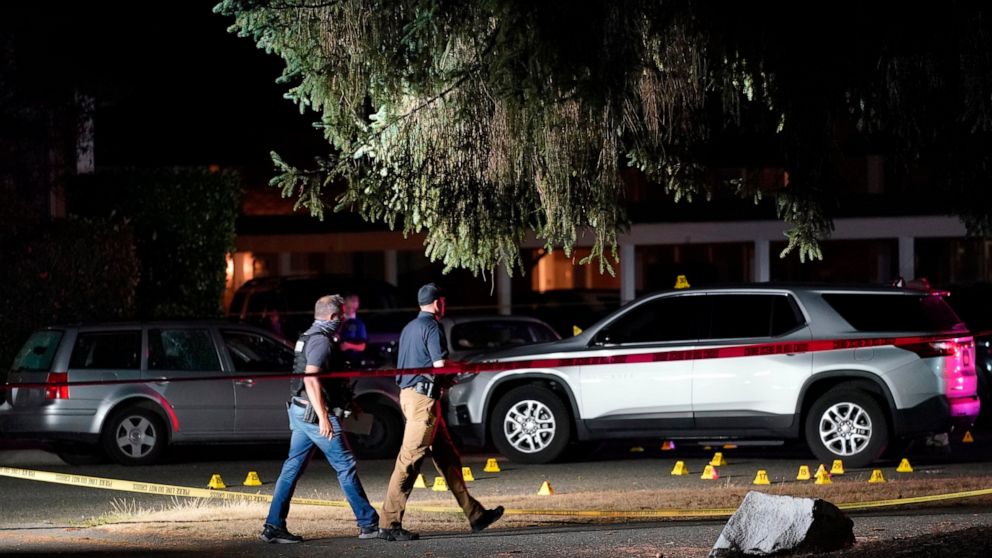 FILE - In this Sept. 3, 2020, file photo, police walk past evidence markers at a scene in Lacey, Wash., where a man suspected of fatally shooting a supporter of a right-wing group in Portland, Ore., was killed as investigators moved in to arrest him.
