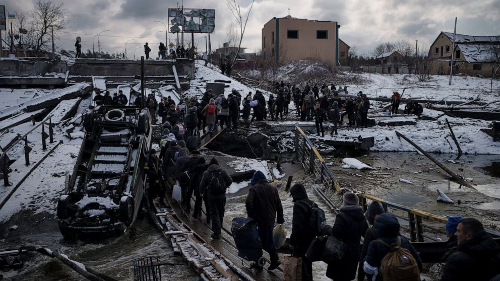 FILE - Ukrainians cross an improvised path under a destroyed bridge while fleeing Irpin, in the outskirts of Kyiv, Ukraine, Tuesday, March 8, 2022. (AP Photo/Felipe Dana)