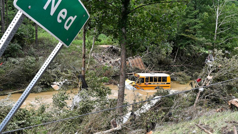 A Perry County school bus lies destroyed after being caught up in the floodwaters of Lost Cree in Ned, Ky., Friday, July 29, 2022. (AP Photo/Timothy D. Easley)