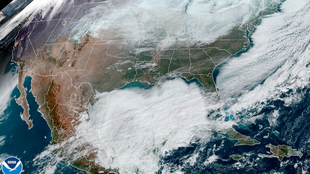 This satellite image made available by NOAA shows weather systems across North America on Saturday, Dec. 24, 2022, at 12:06 p.m. EST. A battering winter storm knocked out power to hundreds of thousands of homes and businesses across the United States