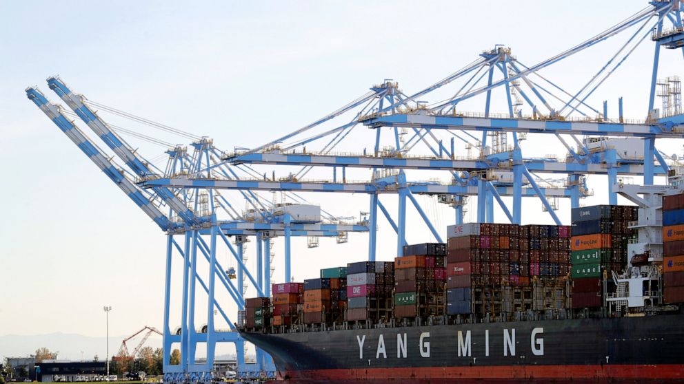 FILE - In this Nov. 4, 2019, file photo, cargo cranes are used to take containers off of a Yang Ming Marine Transport Corporation boat at the Port of Tacoma in Tacoma, Wash. The U.S. trade deficit rose in August to the highest level in 14 years. The 