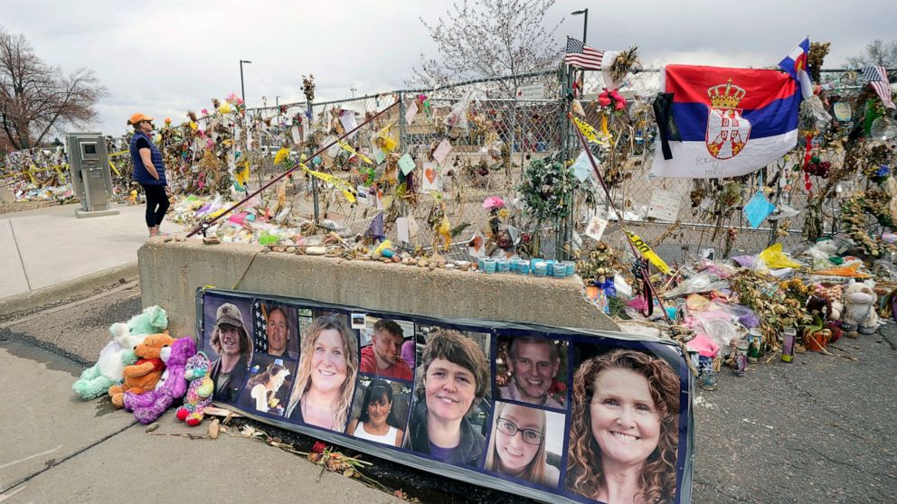 FILE - In this Friday, April 23, 2021, file photo, photographs of the 10 victims of a mass shooting in a King Soopers grocery store are posted on a cement barrier outside the supermarket in Boulder, Colo. Several families and survivors of those kille