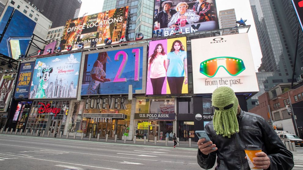 Jon Makay, of Harlem, wears an octopus hat to fend off coronavirus, Wednesday, March 25, 2020, in New York's Times Square. The number of people hospitalized with COVID-19 in New York climbed to 3,800, with close to 900 in intensive care, with the pea