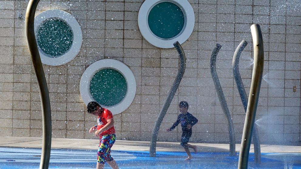 Children play at a water park, Monday, June 13, 2022, in Miami Beach, Fla. More than 100 million Americans are being warned to stay indoors if possible as high temperatures and humidity settle in over states stretching through parts of the Gulf Coast