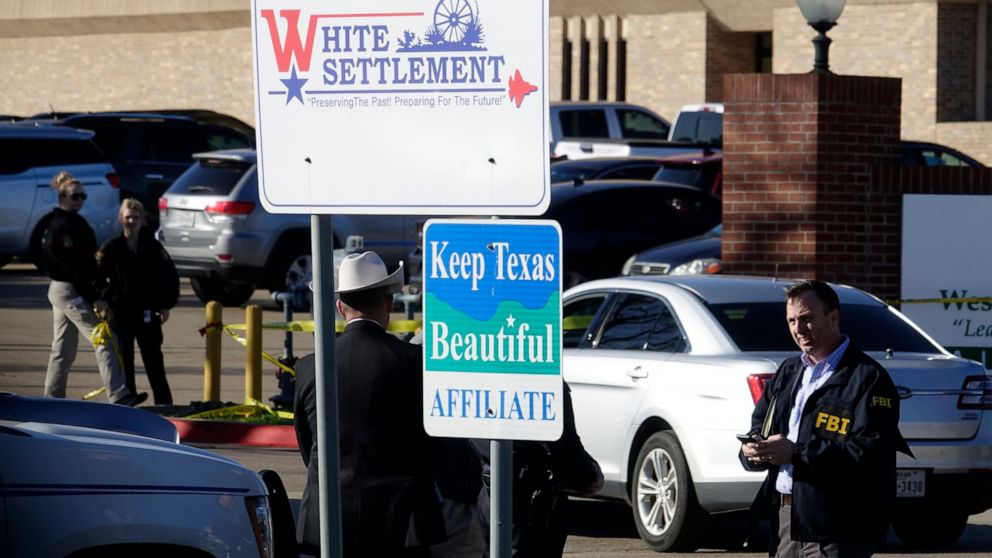 An FBI agent stands outside West Freeway Church of Christ as authorities continue to investigate a fatal shooting at the church, Sunday, Dec. 29, 2019, in White Settlement, Texas. (AP Photo/David Kent)