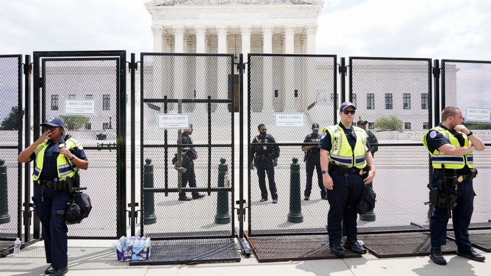 Authorities stand guard by a fence outside the Supreme Court following Supreme Court's decision to overturn Roe v. Wade in Washington, Friday, June 24, 2022. The Supreme Court has ended constitutional protections for abortion that had been in place n