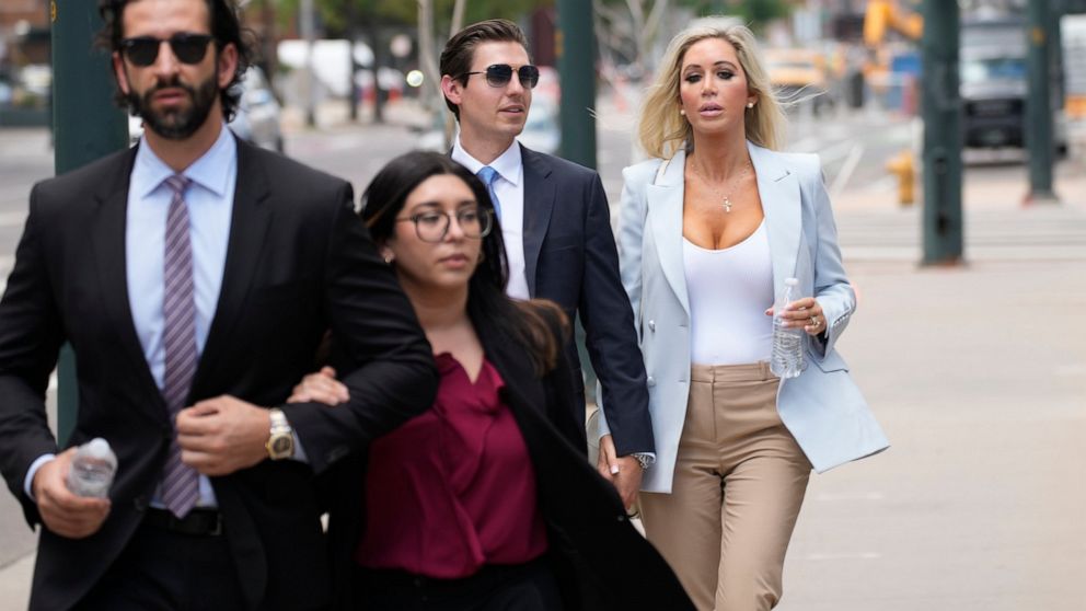 FILE - The son, left, and daughter, back right, of Pittsburgh dentist Lawrence "Larry" Rudolph head into federal court for the afternoon session of the trial, July 13, 2022, in Denver. Rudolph accused of shooting and killing his wife in their cabin a