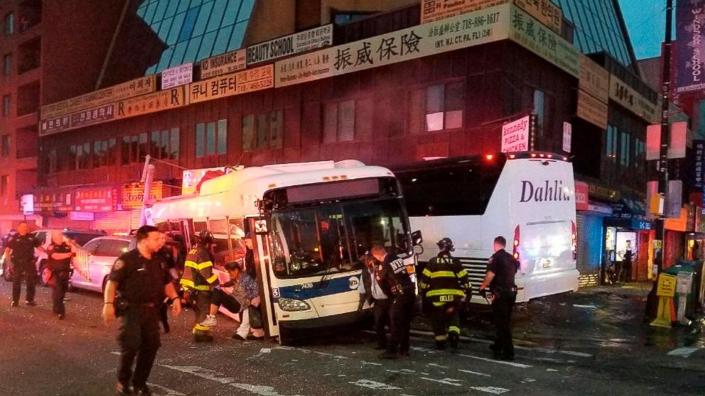 FILE - In this Monday, Sept. 18, 2017 photo provided by the NYPD's 109th Precinct, officers respond to a collision involving two buses on Main Street in the Queens borough of New York. Federal safety investigators say a freak accident involving a dro