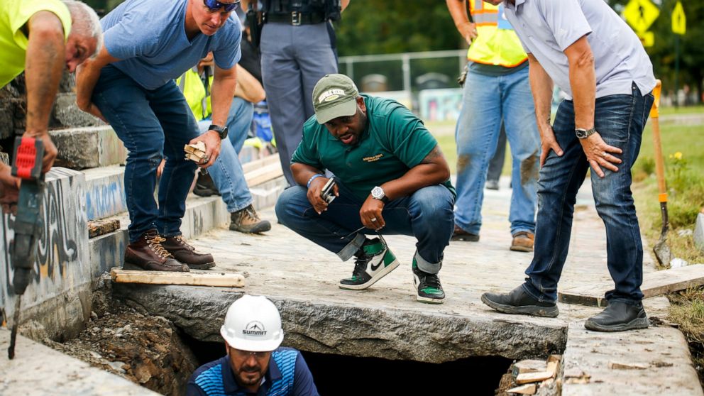 Devon Henry, owner of the construction company that removed the Confederate Gen. Robert E. Lee statue, center, looks on as crews work on retrieving a 134-year-old time capsule at Monument Avenue, Thursday, Sept. 9, 2021, in Richmond, Va. The time cap
