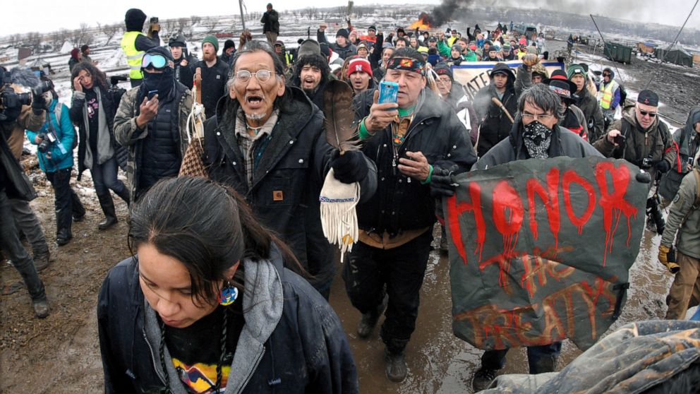 FILE - In this Feb. 22, 2017, file photo, a large crowd representing a majority of the remaining Dakota Access Pipeline protesters march out of the Oceti Sakowin camp near Cannon Ball, N.D. After President Joe Biden revoked Keystone XL's presidential