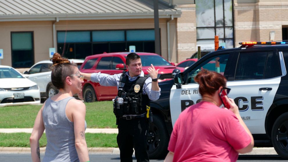 A law enforcement officer helps people cross the street at Uvalde Memorial Hospital after a shooting was reported earlier in the day at Robb Elementary School, Tuesday, May 24, 2022, in Uvalde, Texas. (Billy Calzada/The San Antonio Express-News via AP)