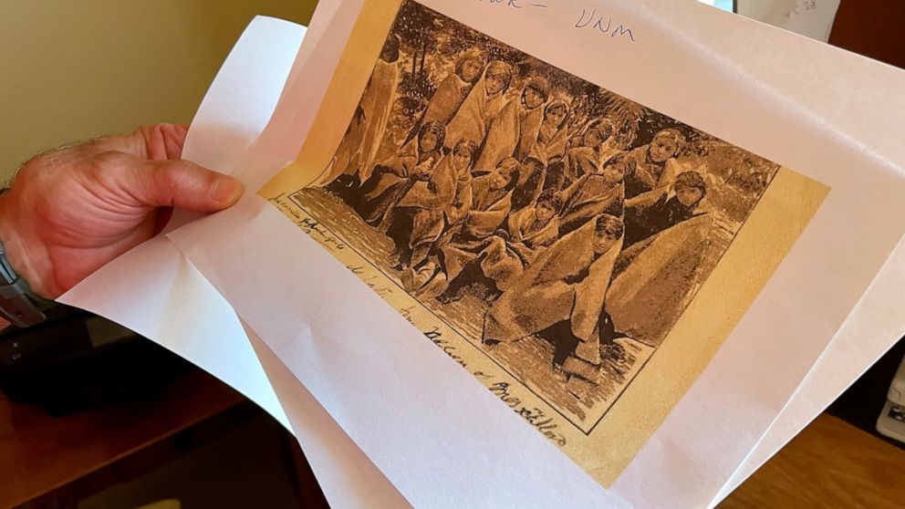 FILE - In this July 8, 2021, photo, adjunct history professor and research associate Larry Larrichio holds a copy of a late 19th century photograph of pupils at an Indigenous boarding school in Santa Fe during an interview in Albuquerque, N.M. A new 