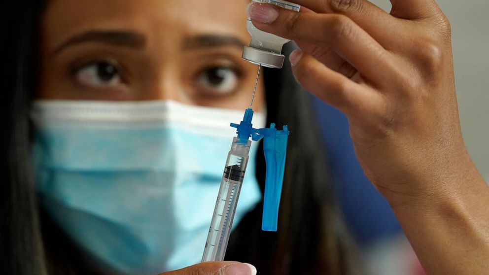 Licensed practical nurse Yokasta Castro, of Warwick, R.I., draws a Moderna COVID-19 vaccine into a syringe at a mass vaccination clinic, Wednesday, May 19, 2021, at Gillette Stadium, in Foxborough, Mass. A month after every adult in the U.S. became e