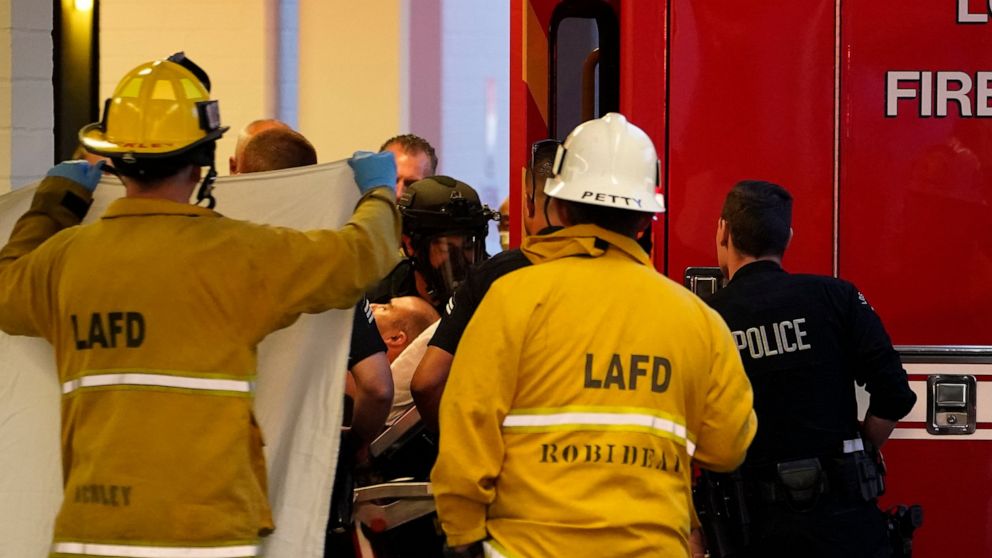 A suspect who stabbed multiple people and barricaded himself inside the Encino Hospital Medical Center is transported into a waiting ambulance after being extracted from the hospital in Encino, Calif., late Friday, June 3, 2022. (AP Photo/Damian Dova