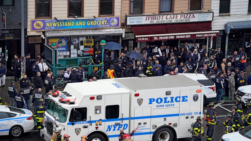 FILE - Emergency personnel gather at the entrance to a subway station in the Brooklyn borough of New York, after a gunman filled a rush-hour subway train with smoke and shot multiple people, April 12, 2022. A woman wounded in the shooting has filed a