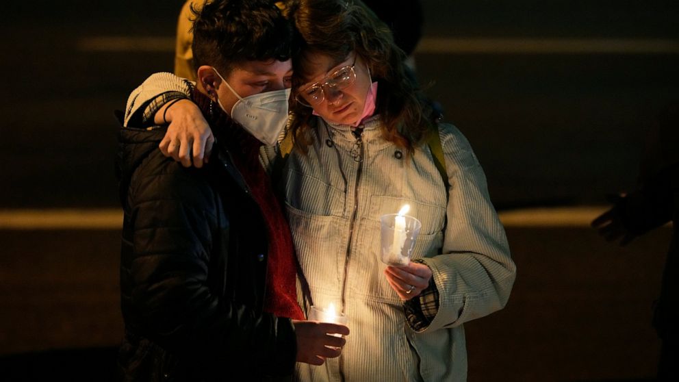 People embrace during a candlelight vigil on a corner near the site of a mass shooting at a gay bar Monday, Nov. 21, 2022, in Colorado Springs, Colo. (AP Photo/Jack Dempsey)