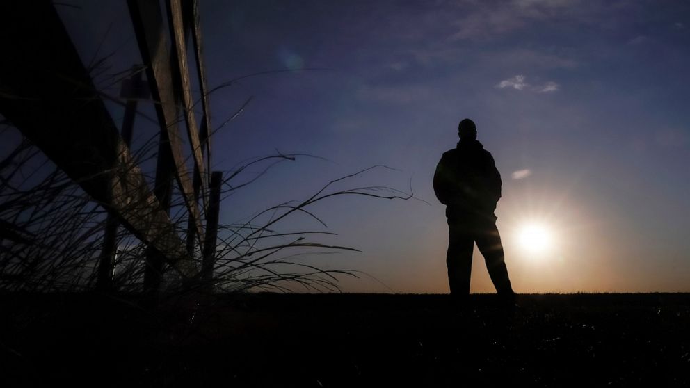 Lateef Dowdell watches the sunrise from what remains of land once belonging to his uncle Gil Alexander, who was the last active Black farmer in the community of Nicodemus, Kan., Thursday, Jan. 14, 2021. Dowdell moved back to Nicodemus, a settlement f
