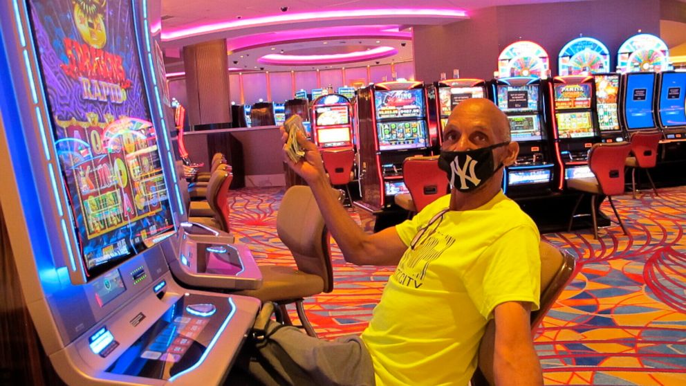 FILE- In this July 2, 2020 file photo, Gary Royster of Atlantic City holds up a wad of cash he used to gamble at the Hard Rock casino in Atlantic City on the day the casino reopened after being shut down for months amid the coronavirus outbreak. On M