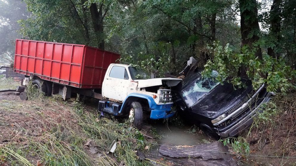 A truck and a car sit in a creek Sunday, Aug. 22, 2021, after they were washed away the day before in McEwen, Tenn. Heavy rains caused flooding in Middle Tennessee and have resulted in multiple deaths as homes and rural roads were washed away. (AP Ph